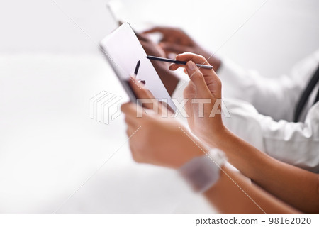 Broadening the horizons of business with technology. two businesspeople using their touchpads. 98162020