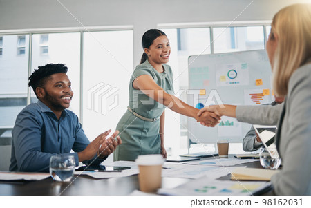 Business people, woman and handshake at meeting, planning and chart on board for target, success or goal. Corporate finance group, applause and celebration for profit, promotion or vision in New York 98162031