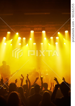 Concert, party and music with a crowd or audience of people watching a live performance on stage. Event, hands and festival with man and woman friends dancing at a social celebration for fun Concert, party and music with a crowd or audience of people watching a live performance on stage. Event, hands and festival with man and woman friends dancing at a social celebration for fun 98162255