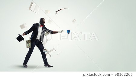 Male illusionist performing tricks . Mixed media 98162265