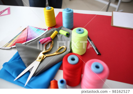 Sewing accessories and fabric on table in atelier 98162527