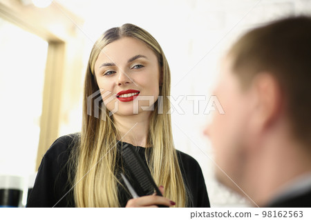 Portrait of young beautiful woman hairdresser communicates in beauty salon with client 98162563