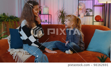 Siblings children girls talking, making friendly conversation, gossiping, telling storys at home 98162691