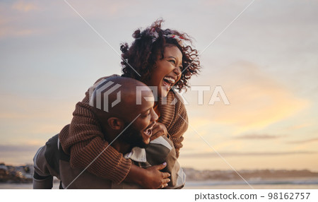 Black couple, travel and beach fun while laughing on sunset nature adventure and summer vacation or honeymoon with a piggy back ride. Comic, energy and black man and woman love on ocean holiday Black couple, travel and beach fun while laughing on sunset nature adventure and summer vacation or honeymoon with a piggy back ride. Comic, energy and black man and woman love on ocean holiday 98162757