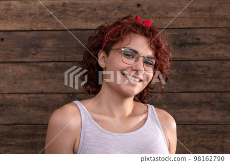Portrait of a girl in a gray sports T-shirt with curly hair. 98162790