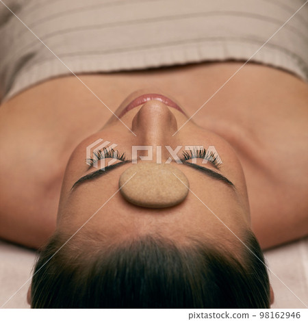 Being pampered from top to toe. A young woman lying with her eyes closed on a massage bed. 98162946