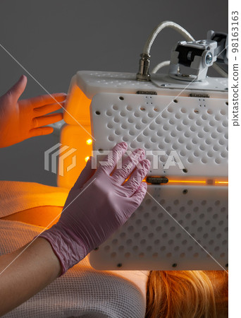 Young woman having photodynamic therapy in beauty salon 98163163
