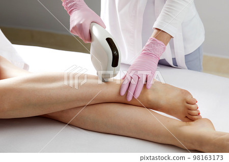 Laser hair removal on ladies legs in beauty salon 98163173