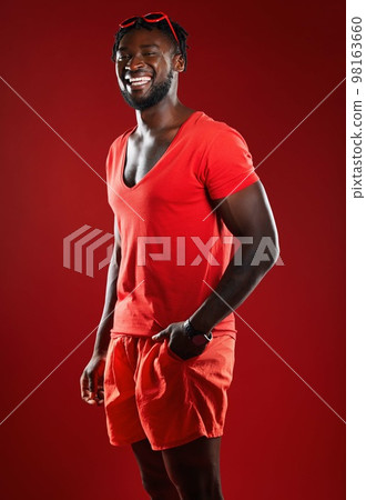 Black man, studio portrait and sport clothes with smile, sunglasses or happiness by red background. Model, man and happy with summer fashion, beauty and sports style for health, self care or wellness 98163660