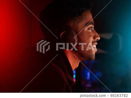 Headphones, gaming and neon with a man streamer playing a video game online for a subscription service. Gamer, streaming and esports with a male geek or nerd enjoying computer games in a mancave Headphones, gaming and neon with a man streamer playing a video game online for a subscription service. Gamer, streaming and esports with a male geek or nerd enjoying computer games in a mancave 98163782
