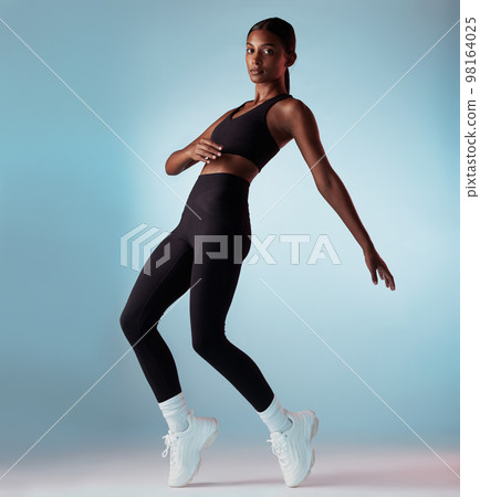Fitness, health and body black woman in studio portrait dancing for performance, workout and training marketing mock up. Sneakers, shoes or fashion model dancer balance on legs for an exercise dance Fitness, health and body black woman in studio portrait dancing for performance, workout and training marketing mock up. Sneakers, shoes or fashion model dancer balance on legs for an exercise dance 98164025