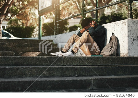 Sad, depression and black man with anxiety at college, stress and headache from education on the stairs at campus. Depressed, frustrated and student with a mental health problem crying at university Sad, depression and black man with anxiety at college, stress and headache from education on the stairs at campus. Depressed, frustrated and student with a mental health problem crying at university 98164046