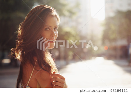 Looking gorgeous in the afternoon sun. an attractive young woman in an urban setting. 98164111