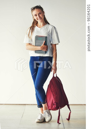 Studying, books and student at a college for education, knowledge and scholarship with a smile. School, happy and portrait of a girl ready for university with backpack on campus for higher education 98164201