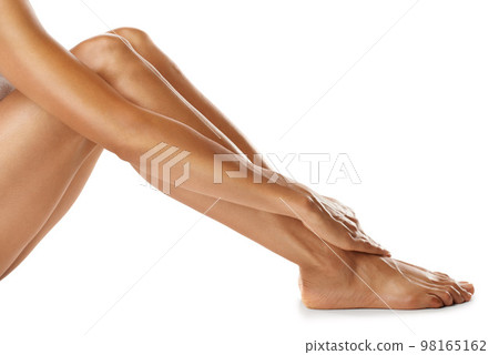 Woman, legs and skincare in studio for cleaning, hygiene and self love on white background. Beauty, leg and girl relax after luxury, pamper and cosmetic treatment for soft, smooth and glowing skin 98165162