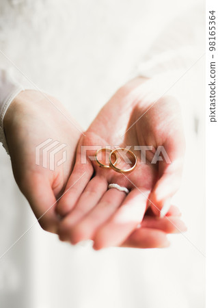 Beautiful luxury bride in elegant white dress holds wedding rings in the hands Beautiful luxury bride in elegant white dress holds wedding rings in the hands 98165364