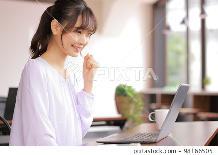 A young woman who completes the document creation and makes a guts pose with her left hand_1 98166505