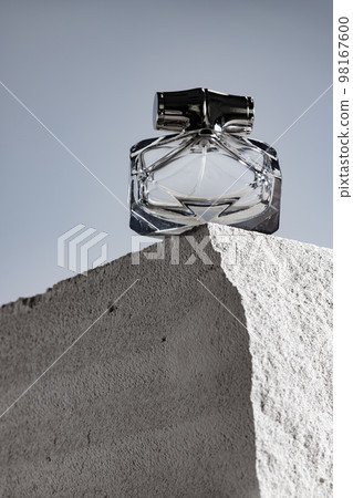Transparent fragrance bottle on gray .cinder block Transparent fragrance bottle on gray .cinder block 98167600