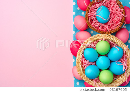 Painted Easter eggs in decorative nest on pink background Painted Easter eggs in decorative nest on pink background 98167605