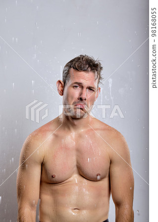 caucasian young man taking shower in bathroom, relaxed man is upset, isolated caucasian young man taking shower in bathroom, relaxed man is upset, isolated 98168055