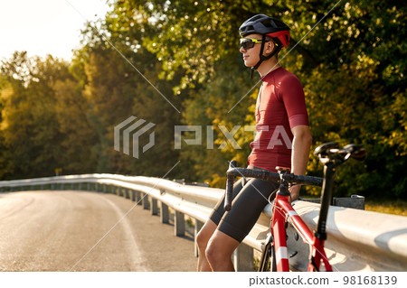 relaxed young cyclist man resting after intensive driving a bike,take a break. relaxed young cyclist man resting after intensive driving a bike,take a break. 98168139