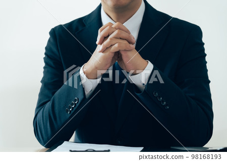 Businessman holding hands and listening Businessman holding hands and listening 98168193