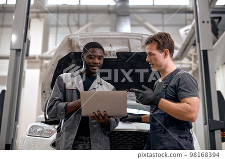Car Mechanic And Repairman Checking Diagnostics Results on Laptop Computer 98168394