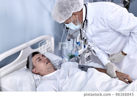 Senior Male Doctor Check the Pulse and the Patient's Health Condition Lying On Bed 98168843