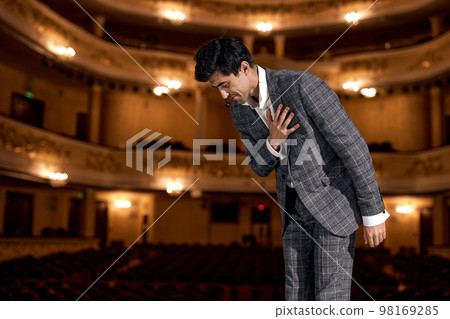 man Presenter on Stage is expression gratitude to audience after performance. man Presenter on Stage is expression gratitude to audience after performance. 98169285