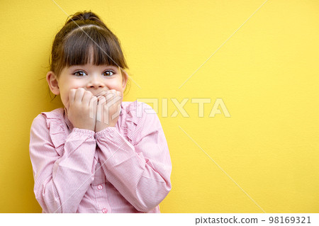 little caucasian child girl is surprised by something, holding hands on cheek 98169321