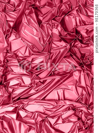 Shiny crumpled foil surface for textured background toned in trendy magenta color of year 2023. Backdrop for your design. Copy space. 98170368