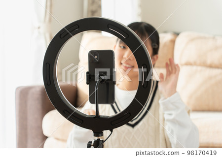 Teenage girl enjoying video shooting with selfie 98170419
