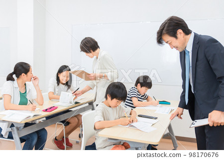 Asian cram school teacher teaching elementary school students to study at cram school (summer course) 98170676