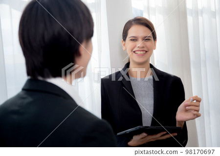 Young manager talking with secretary about report marketing on digital tablet for planning. Young manager talking with secretary about report marketing on digital tablet for planning. 98170697