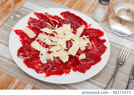 Beef carpaccio cold appetizer with parmesan, on plate 98171473