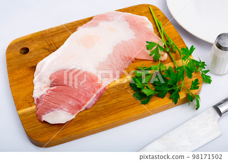 Preparation of raw pork cinch parsley and garlic on wooden board Preparation of raw pork cinch parsley and garlic on wooden board 98171502