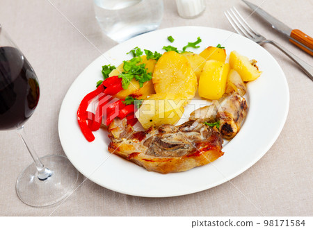 Side dish of baked lamb leg with potatoes and pepper 98171584