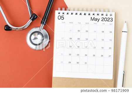 A stethoscope medical and May 2023 desk calendar with pen on the beautiful background. 98171909