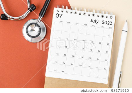 A stethoscope medical and July 2023 desk calendar with pen on the beautiful background. 98171910