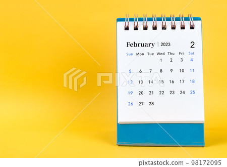 The February 2023 desk calendar on yellow color background. 98172095