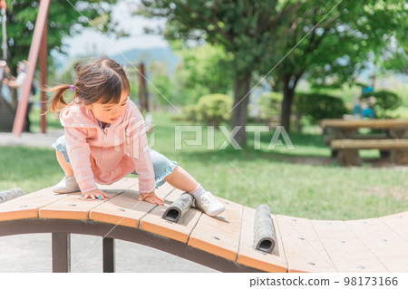 Children playing and exercising on park playground equipment (girls, toddlers, kindergarteners) Children playing and exercising on park playground equipment (girls, toddlers, kindergarteners) 98173166