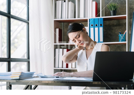 Business woman overwork on laptop computer and neck pain with at work in office, girl stress and illness chronic with office syndrome, health and emotion concept Business woman overwork on laptop computer and neck pain with at work in office, girl stress and illness chronic with office syndrome, health and emotion concept 98173324
