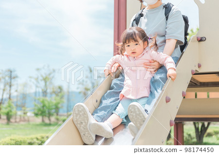 Children and moms (girls, toddlers, kindergarteners) playing and exercising on park playground equipment and slides 98174450