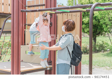 Children and moms (girls, toddlers, kindergarteners) playing and exercising on park playground equipment and ladders 98174451