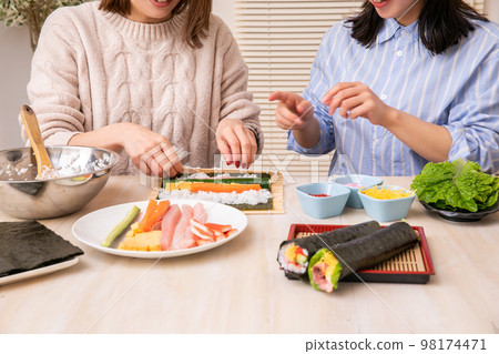 Woman enjoying hand-rolled sushi sushi 98174471