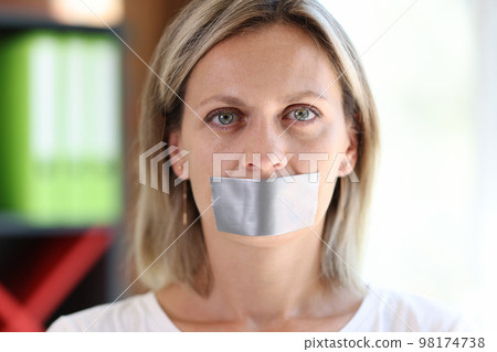 Woman face with adhesive tape covering mouth. 98174738