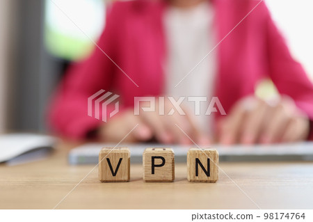 Letters VPN on wooden cubes - Virtual Private Network and Internet user works on computer in background. Letters VPN on wooden cubes - Virtual Private Network and Internet user works on computer in background. 98174764