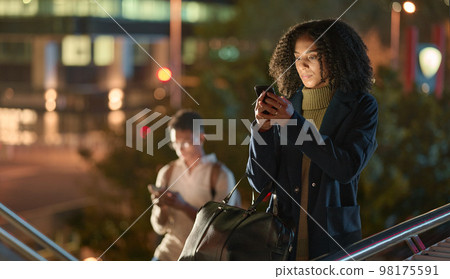 Black woman, phone and social media in the night city for communication, chatting or texting in the outdoors. African American female in social networking on mobile 5G smartphone in the urban city Black woman, phone and social media in the night city for communication, chatting or texting in the outdoors. African American female in social networking on mobile 5G smartphone in the urban city 98175591