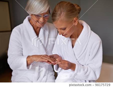 Making sure that her nails are perfect. Granddaughter paints her grandmothers nails. Making sure that her nails are perfect. Granddaughter paints her grandmothers nails. 98175729