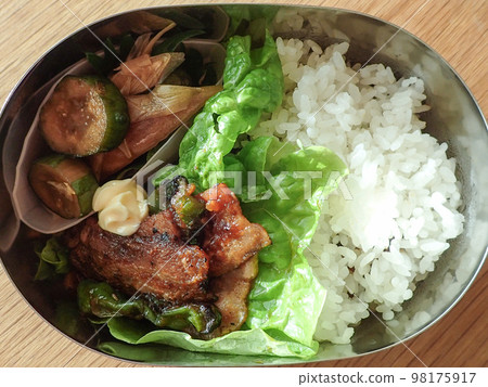 Bento box of stir-fried pork belly and pickled Japanese ginger and cucumber 98175917